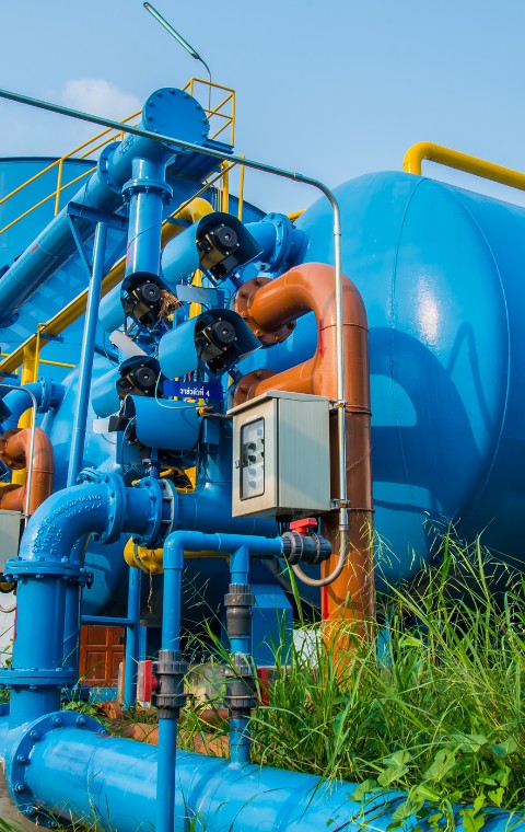 Imagem de alguns canos azuis no teto de um edifício em construção